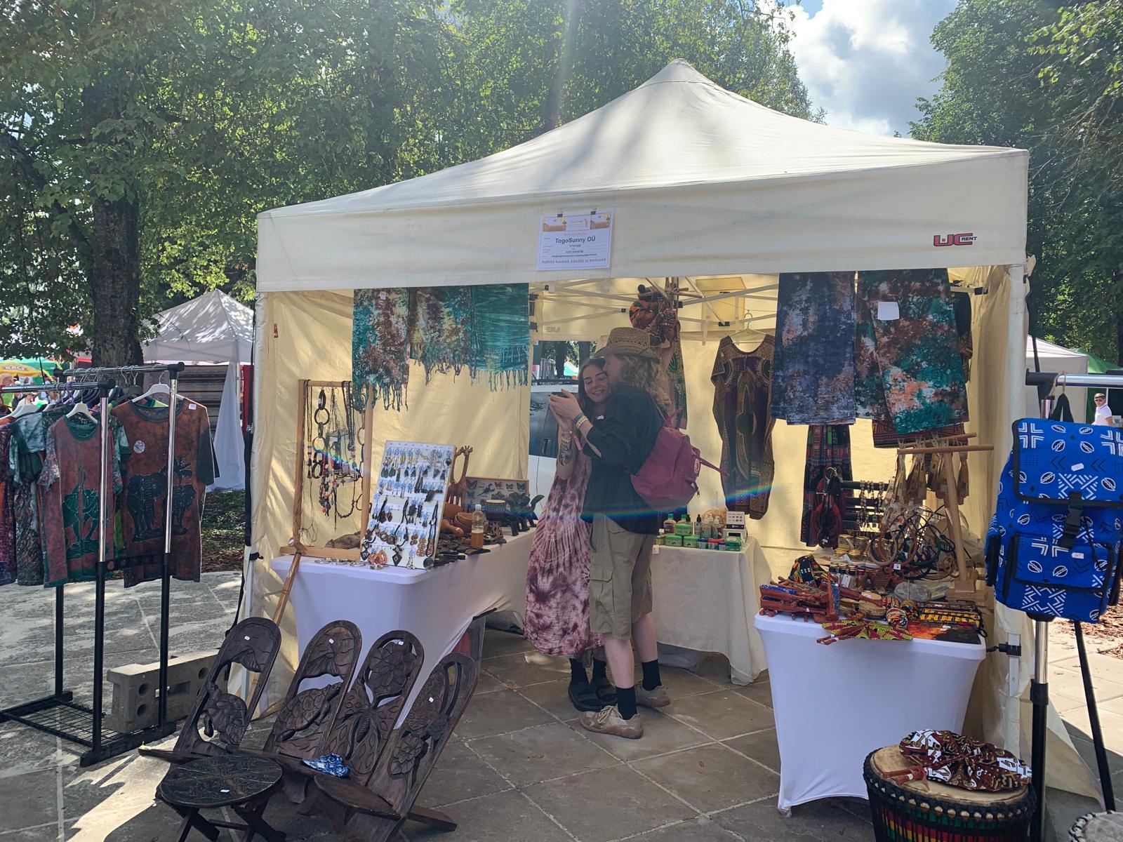 Customer hugging a TogoSunny team member in front of the tent