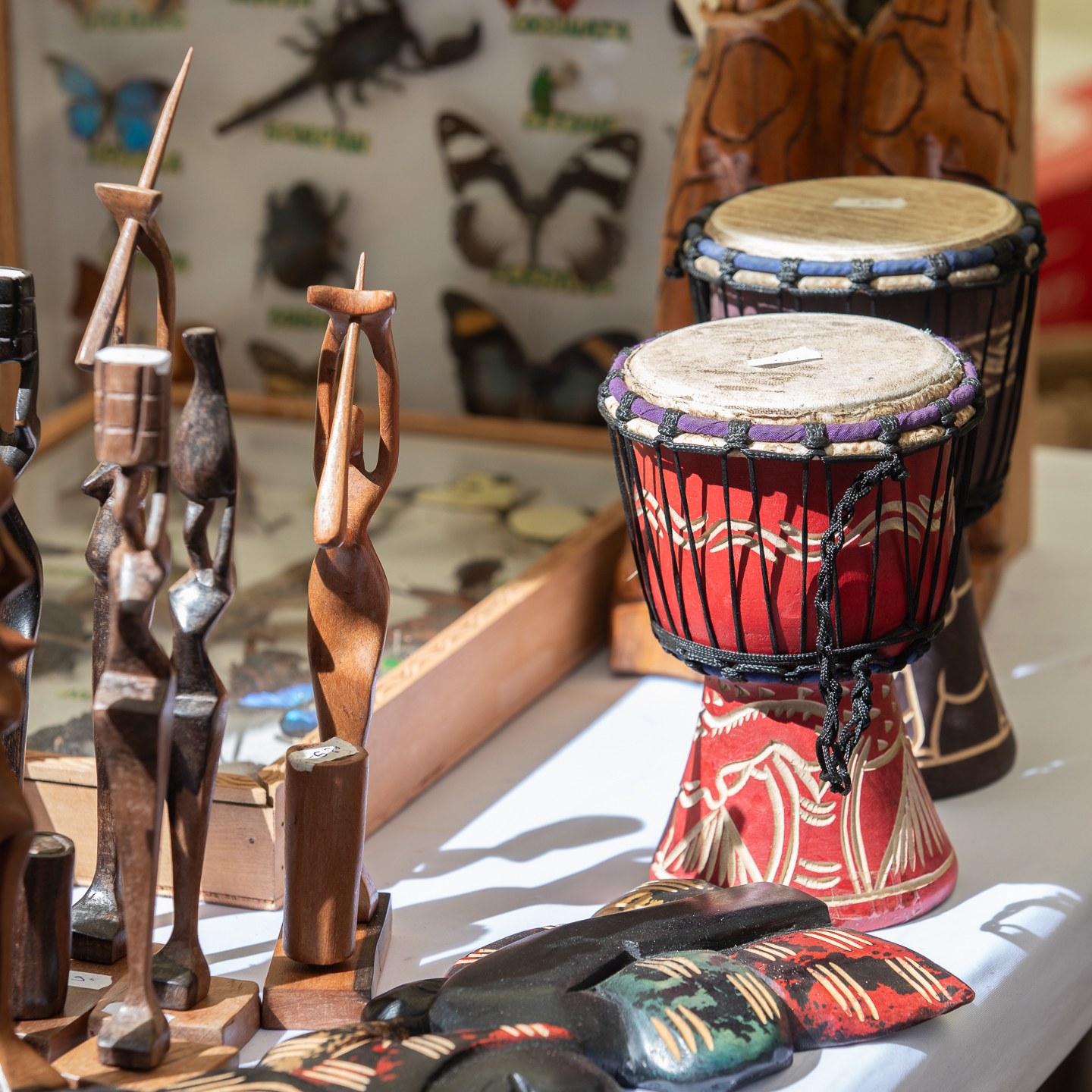 Carved wooden figures and djembe drums close-up